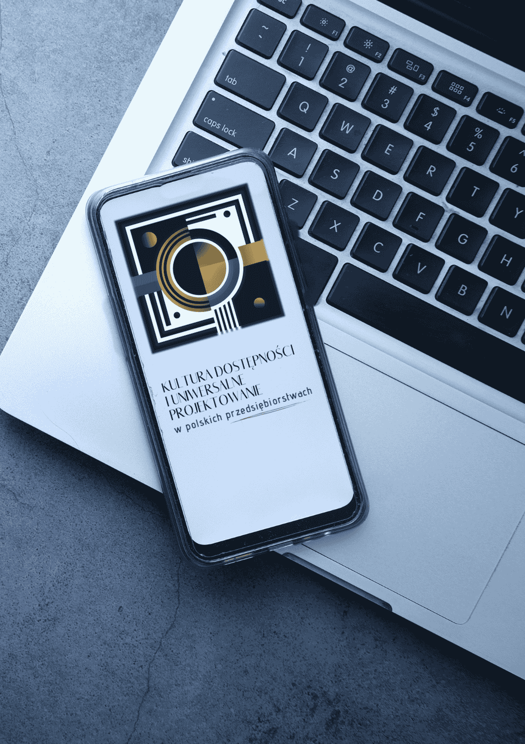 Smartfon leżący na laptopie z ikoną Programu i Tytułem "Kultura dostępności polskich przedsiębiorstwach"