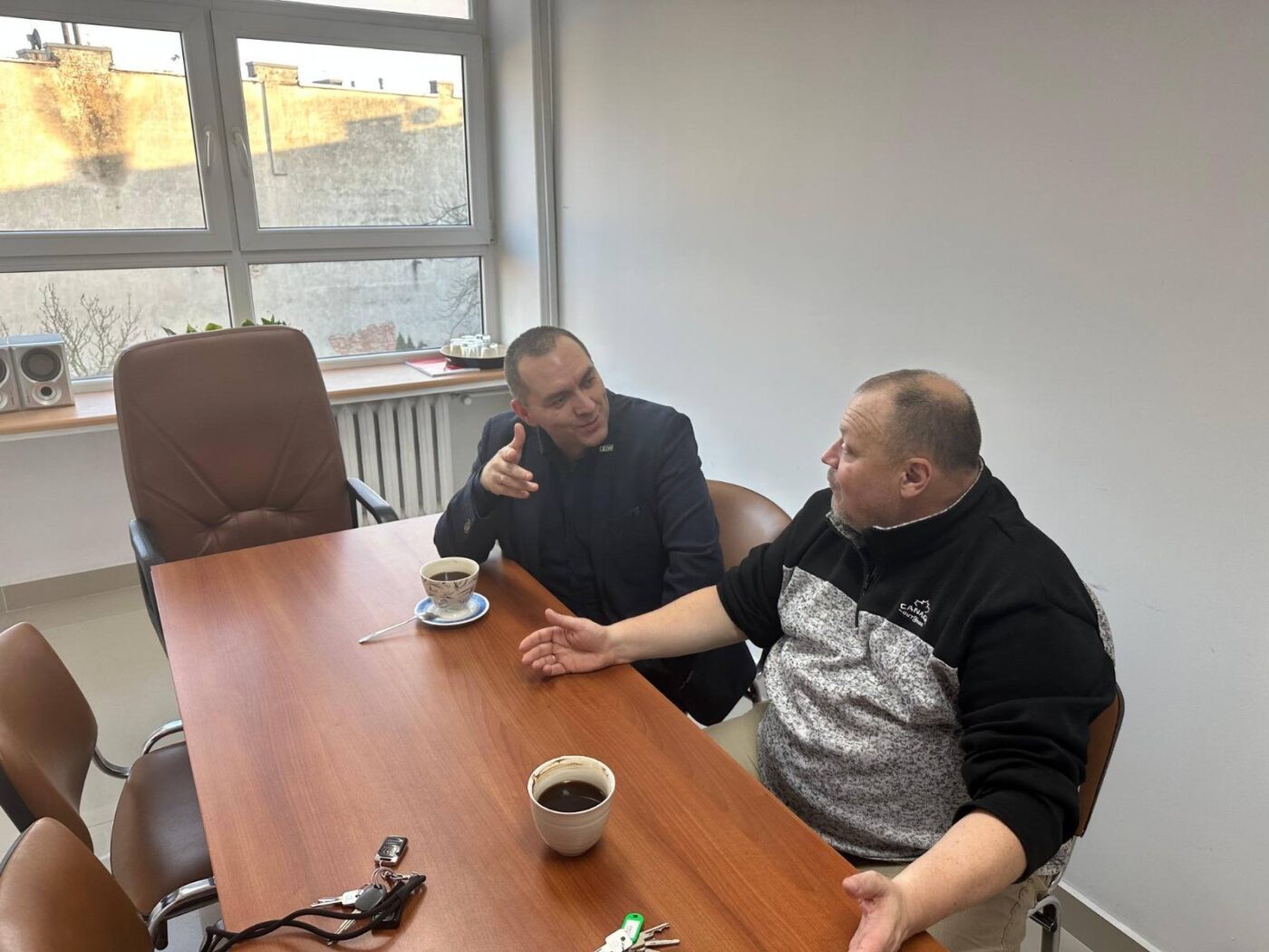 Specjaliści podczas doradztwa poszkoleniowego przy kawie.